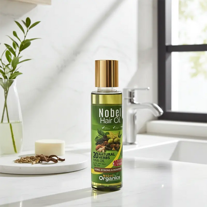 Bottle of Nobel Hair Oil on a bathroom counter with a plant and soap in the background